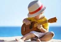 Photo of child with ukelele on the beach.